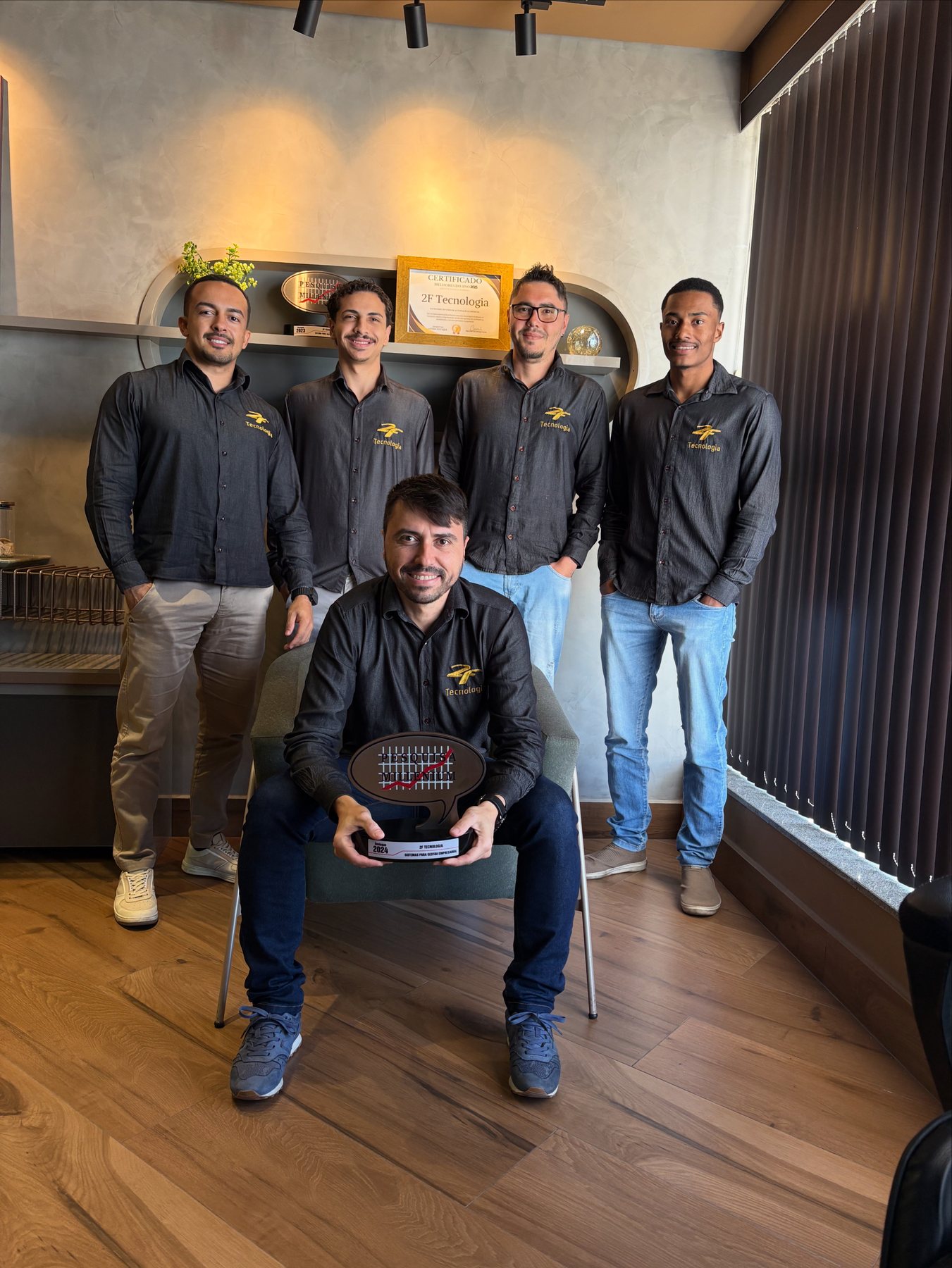 Equipe da 2F Tecnologia no escritório em Guaçuí, com o troféu Pesquisa Millenium e o certificado Melhores do Ano